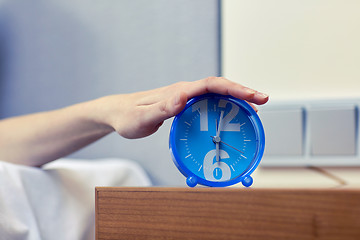 Image showing close up of hand on alarm clock in bedroom