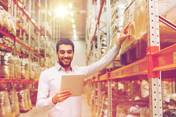 Image showing happy businessman with tablet pc at warehouse