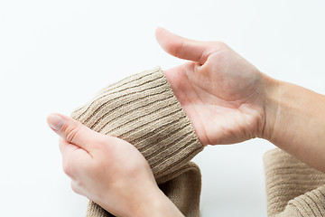 Image showing close up of hands with sweater sleeve