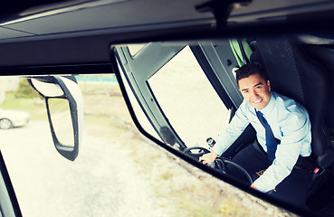 Image showing close up of driver reflection in bus mirror