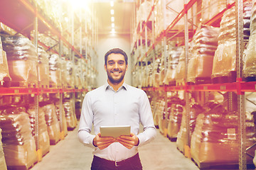 Image showing happy businessman with tablet pc at warehouse