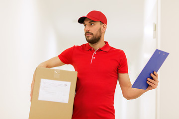 Image showing delivery man with box and clipboard in corridor