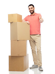 Image showing happy man with cardboard boxes showing thumbs up