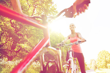 Image showing close up of happy couple riding bicycle outdoors