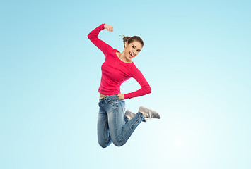 Image showing smiling young woman jumping in air