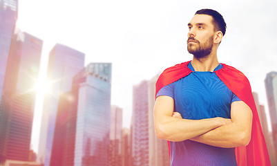 Image showing man in red superhero cape over city skyscrapers