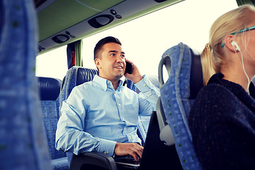 Image showing happy man with smartphone and laptop in travel bus