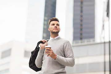 Image showing young man with bag drinking coffee in city