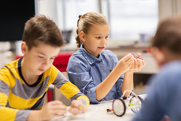 Image showing happy children building robots at robotics school