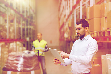 Image showing businessman with tablet pc at warehouse