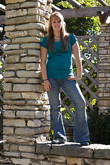 Image showing Teenage Girl Standing on a Brick Wall