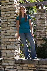 Image showing Teenage Girl Standing on a Brick Wall