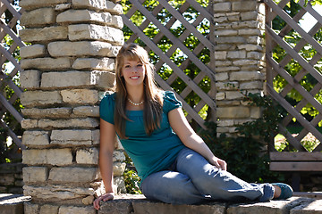 Image showing Pretty Teen Girl Sitting on a Wall