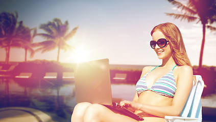 Image showing happy young woman in shades with laptop on beach