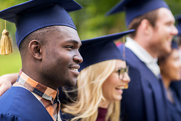 Image showing happy students or bachelors in mortar boards