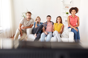 Image showing sad friends watching tv at home