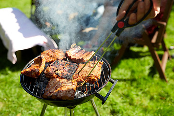 Image showing man cooking meat on barbecue grill at summer party