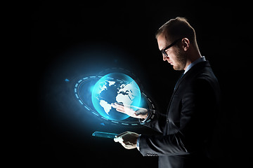 Image showing businessman with tablet pc and earth hologram