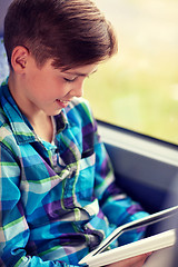 Image showing happy boy with tablet pc in travel bus or train