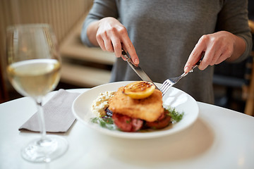 Image showing woman eating fish salad at cafe or restaurant