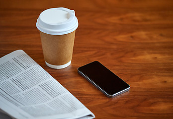 Image showing coffee cup, smartphone and newspaper on table