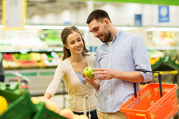 Image showing happy couple buying apples at grocery store