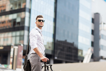 Image showing young man with bicycle on city street