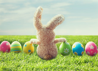 Image showing close up of colored easter eggs and bunny on grass