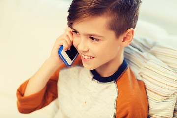 Image showing happy boy calling on smartphone at home