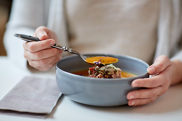 Image showing woman eating pumpkin cream soup at restaurant