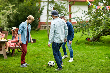 Image showing happy friends playing football at summer garden