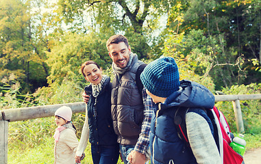 Image showing happy family with backpacks hiking in woods