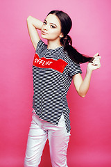 Image showing young pretty teenage woman emotional posing on pink background, fashion lifestyle people concept