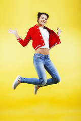 Image showing young pretty brunette girl jumping isolated on yellow background, lifestyle flying people concept close up