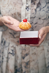 Image showing Woman holding eclair and red box