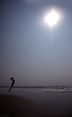 Image showing Silhouette of the jumping lady at the summer beach. Artistic col