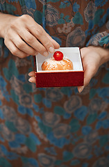 Image showing Woman holding eclair in the box