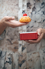 Image showing Woman holding eclair and red box