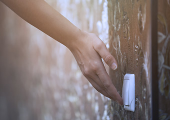 Image showing Woman turning on or off electric switch