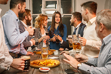 Image showing Group of friends enjoying evening drinks with beer