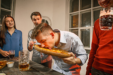 Image showing Group of friends enjoying evening drinks with beer