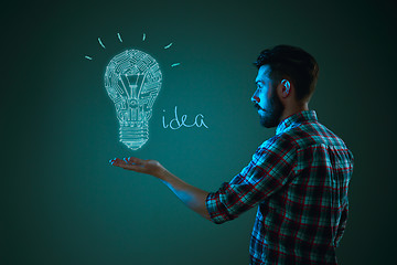 Image showing Handsome young man with idea bulb on blue