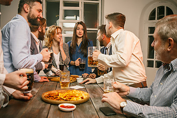 Image showing Group of friends enjoying evening drinks with beer