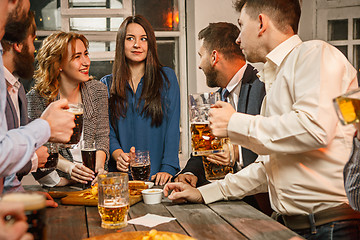 Image showing Group of friends enjoying evening drinks with beer