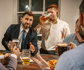 Image showing Group of friends enjoying evening drinks with beer