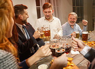 Image showing Group of friends enjoying evening drinks with beer