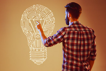 Image showing Handsome young man with idea bulb on blue