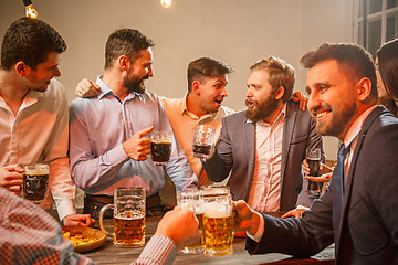 Image showing Group of friends enjoying evening drinks with beer