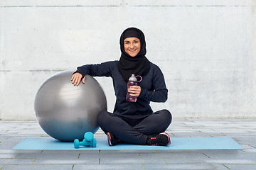 Image showing muslim woman in hijab with fitness ball and bottle