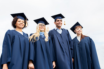 Image showing happy students or bachelors in mortarboards